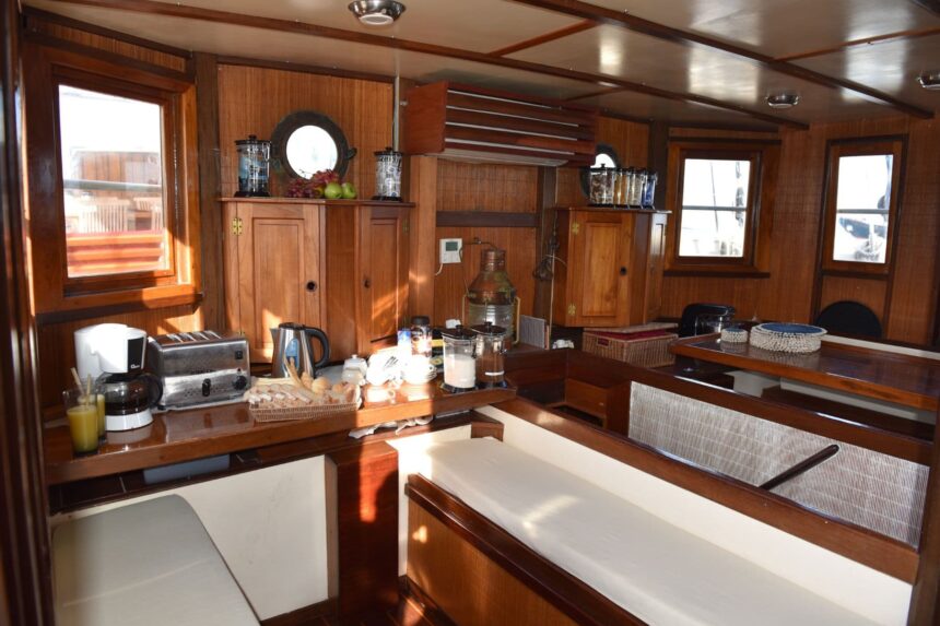 Wood-paneled galley and dining nook aboard the Emperor Raja Laut