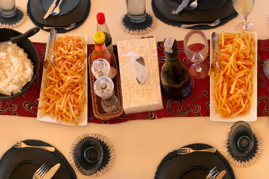 Overhead view of a table set with french fries, rice, and drinks aboard the Emperor Raja Laut