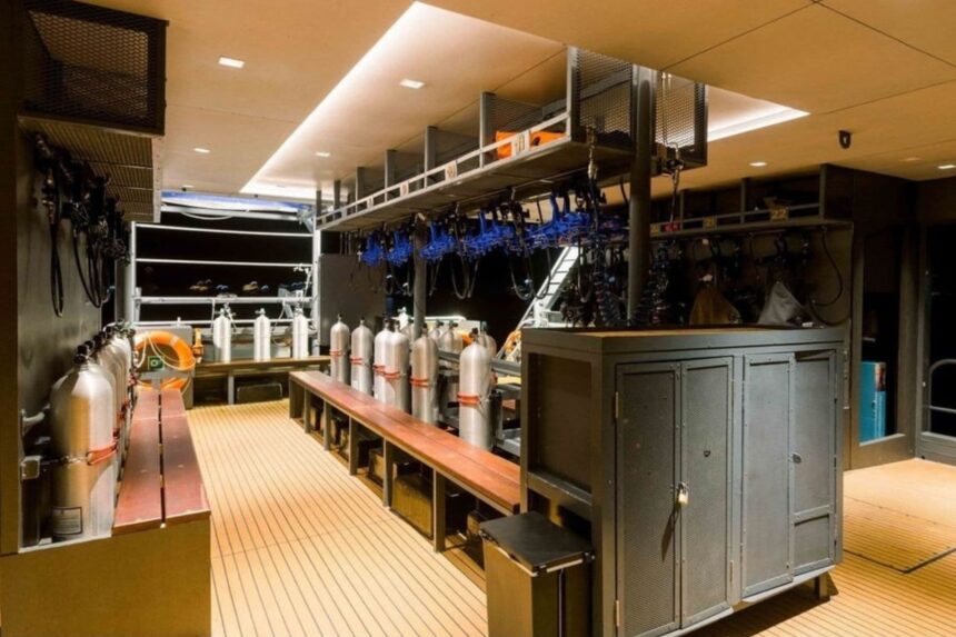 Dive gear storage room aboard the All Star Velocean with tanks and regulators hung ready