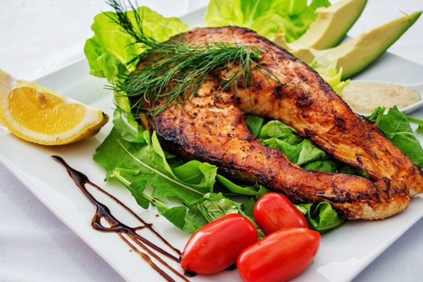 Grilled fish plated with greens, lemon, avocado, and cherry tomatoes aboard the All Star Velocean