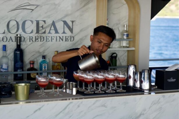 Bartender aboard the All Star Velocean pouring cocktails at the marble bar