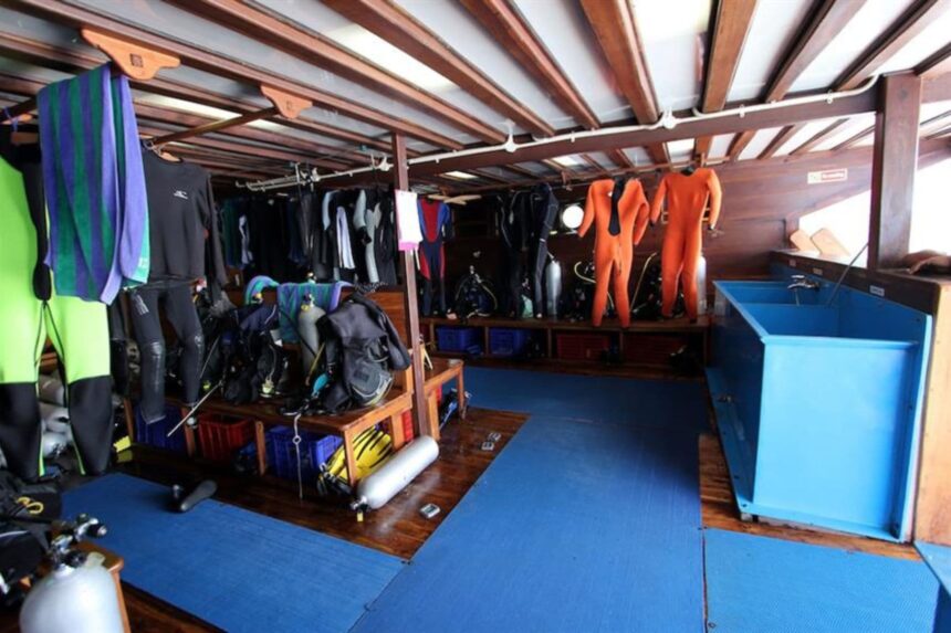 wetsuits and dive gear hanging in the gear room aboard the Amira liveaboard