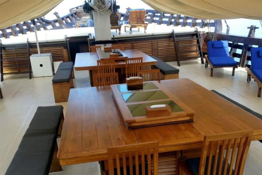 shaded deck seating with wooden tables aboard the Amira liveaboard
