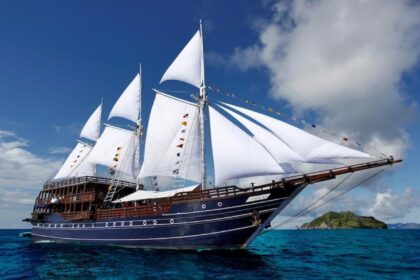 Amira liveaboard phinisi schooner sailing near a small tropical island