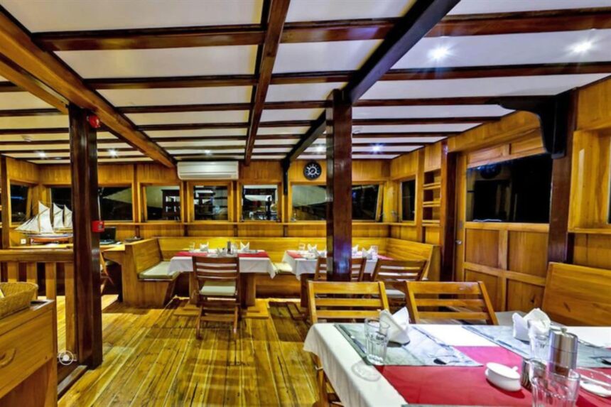wood-paneled dining room set for a meal aboard the Amira liveaboard