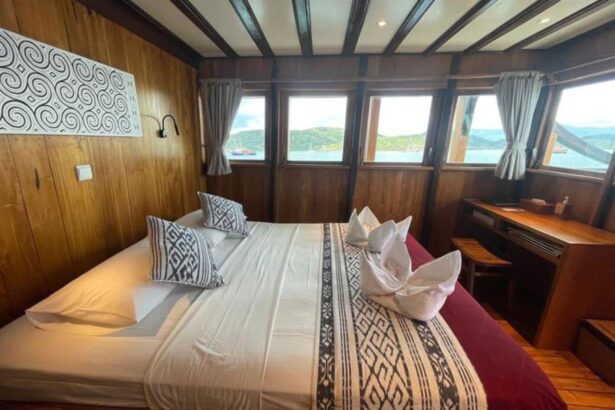 cabin bed with patterned linens and wall art aboard the Amira