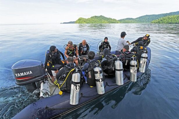 divers geared up aboard a tender boat launching from the Amira