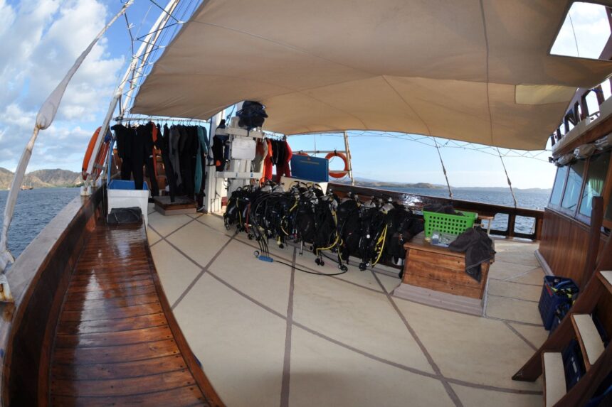 scuba gear lined up on the shaded deck of the Aurora liveaboard