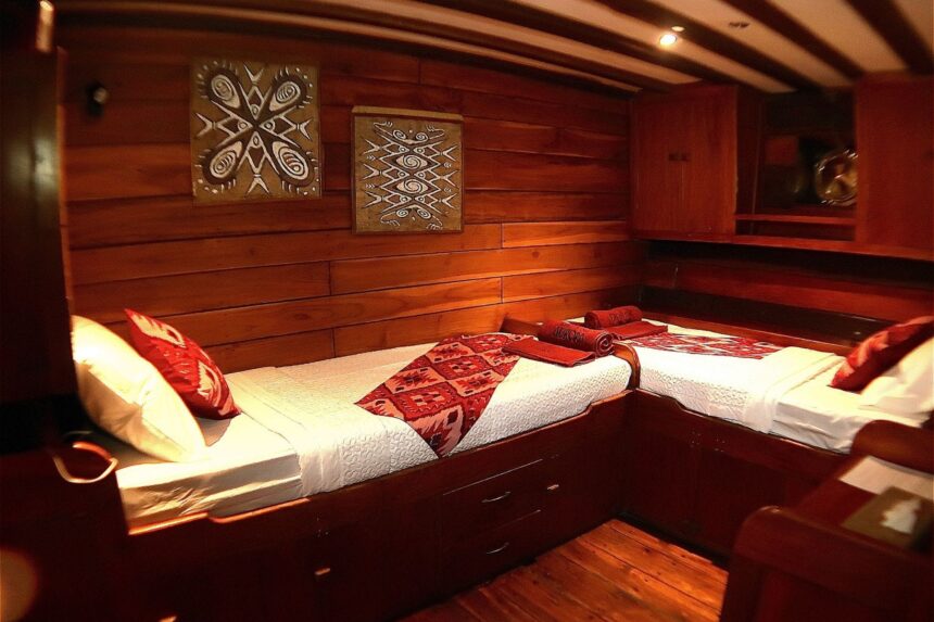 twin beds with patterned linens in a cabin aboard the Aurora