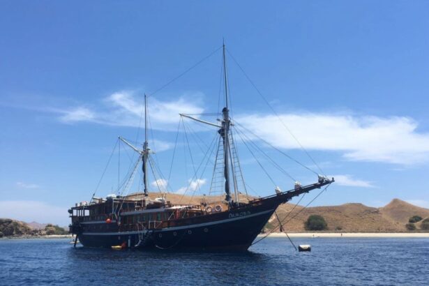 The Aurora liveaboard moored against a dry hillside under a clear blue sky