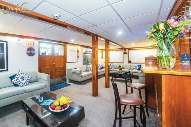 Common lounge area aboard the Nautilus Explorer with sofas, a coffee table, and a bar counter
