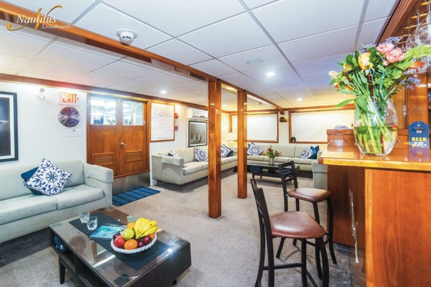 Common lounge area aboard the Nautilus Explorer with sofas, a coffee table, and a bar counter