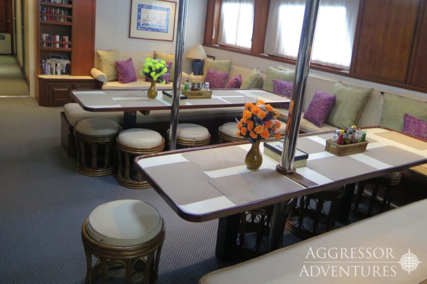 Dining tables set with flowers in the salon of the Raja Ampat Aggressor