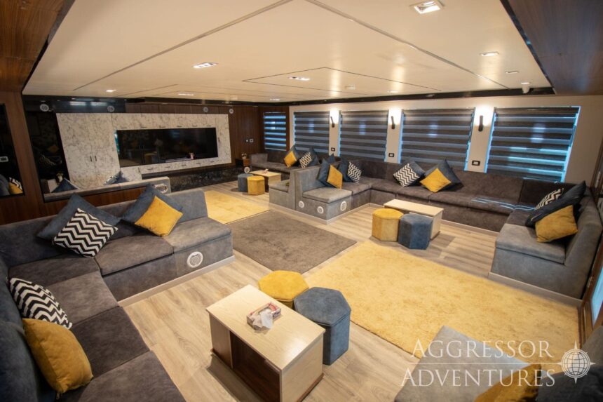 A spacious lounge with sectional sofas and a large TV aboard the Red Sea Aggressor IV