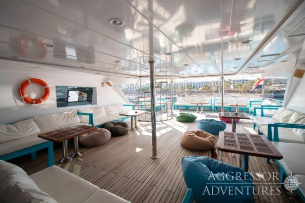 Open air lounge deck with cushioned seating and a lifebuoy aboard the Red Sea Aggressor IV
