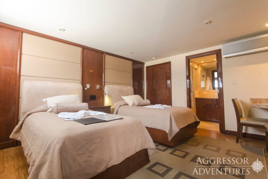 Twin beds and ensuite bathroom in an Okeanos Aggressor II stateroom