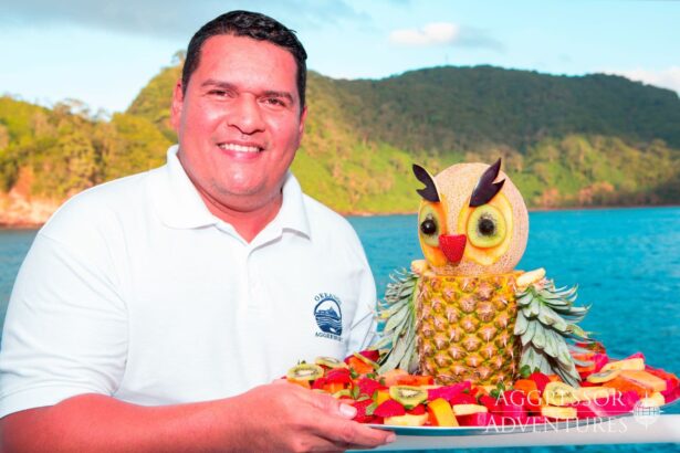 Chef holding a fruit platter carved into an owl shape aboard the Okeanos Aggressor II