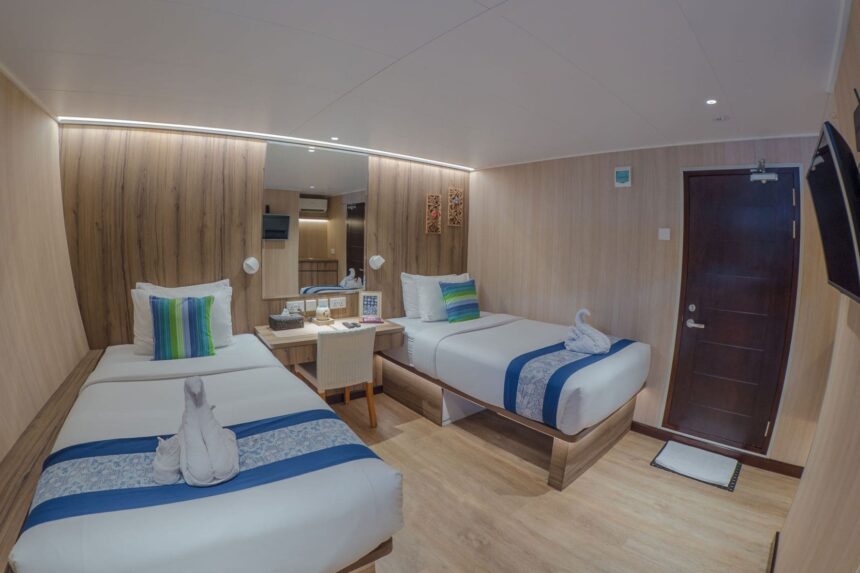 Twin beds with towel swans in a Gaia Love cabin