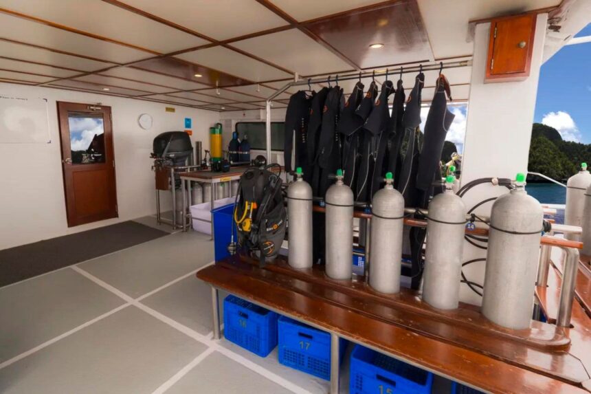 Wetsuits and scuba tanks hanging and staged on the Mermaid II dive deck