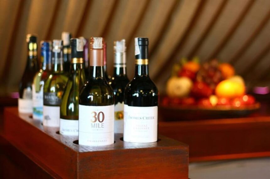 Row of wine bottles displayed on the Mermaid II with a fruit bowl in the background