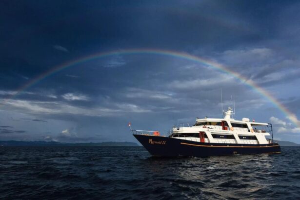 Mermaid II liveaboard sailing under a full rainbow at dusk