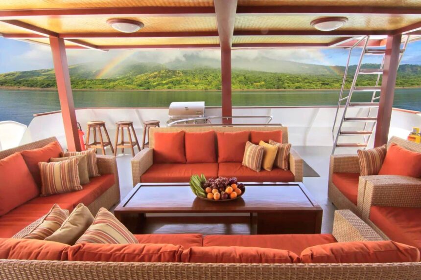 Shaded outdoor lounge on the Mermaid I with cushioned sofas overlooking a rainbow