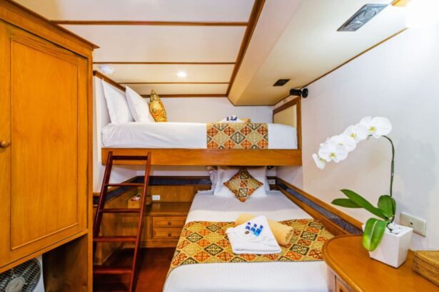 Bunk cabin on the Mermaid I with a wooden ladder and an orchid on the nightstand