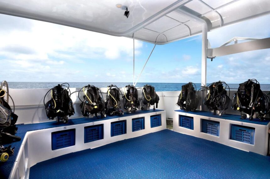 Rows of scuba tanks and BCDs set up on the dive deck of the Galapagos Master