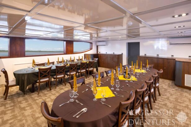 Long dining table set with place settings in the saloon of the Cocos Island Aggressor