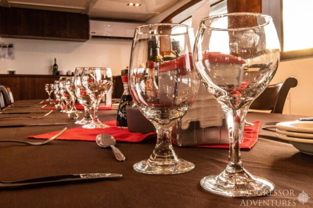 Dinner table set with wine glasses and red napkins on board the vessel