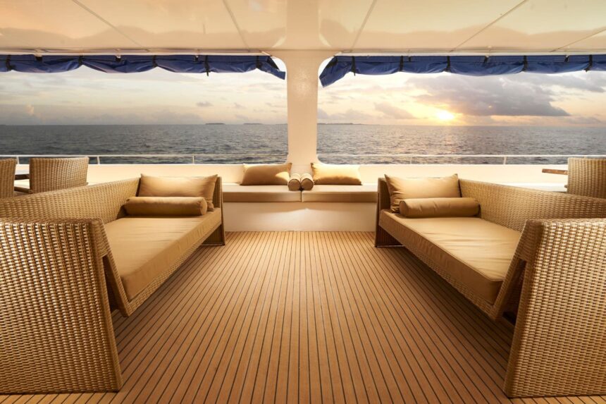 Wicker daybeds on the outdoor deck facing the ocean at sunset