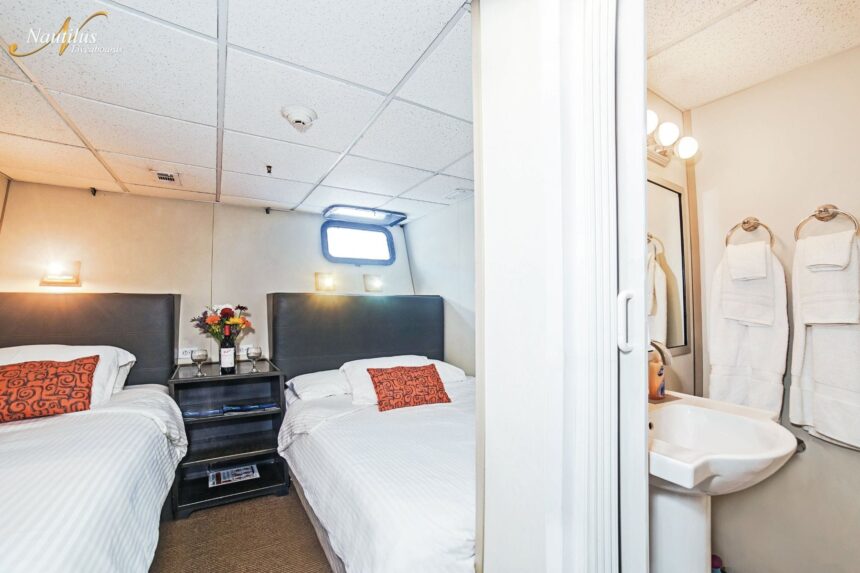Twin-bed stateroom and ensuite bathroom aboard the Nautilus Belle Amie