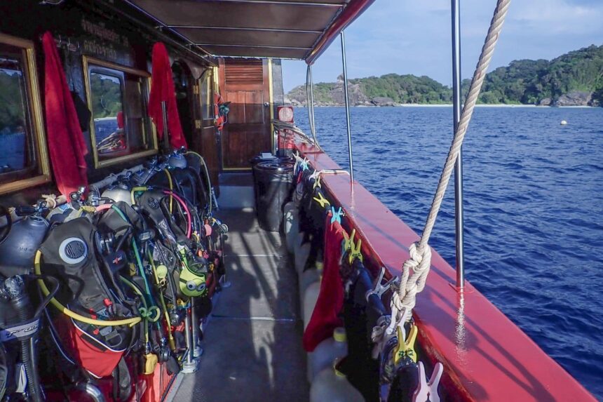Rows of scuba gear hanging along the deck of The Junk liveaboard