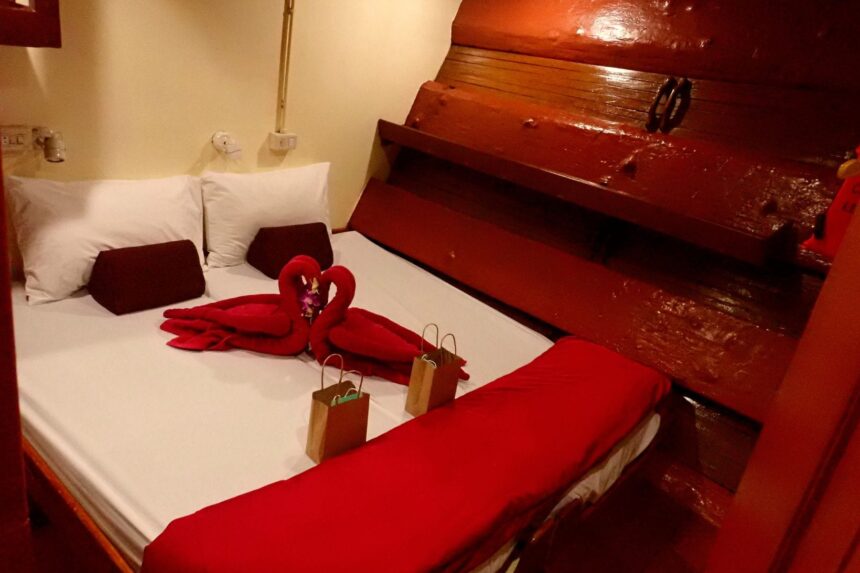 Cabin bed decorated with towel swans and gift bags aboard The Junk