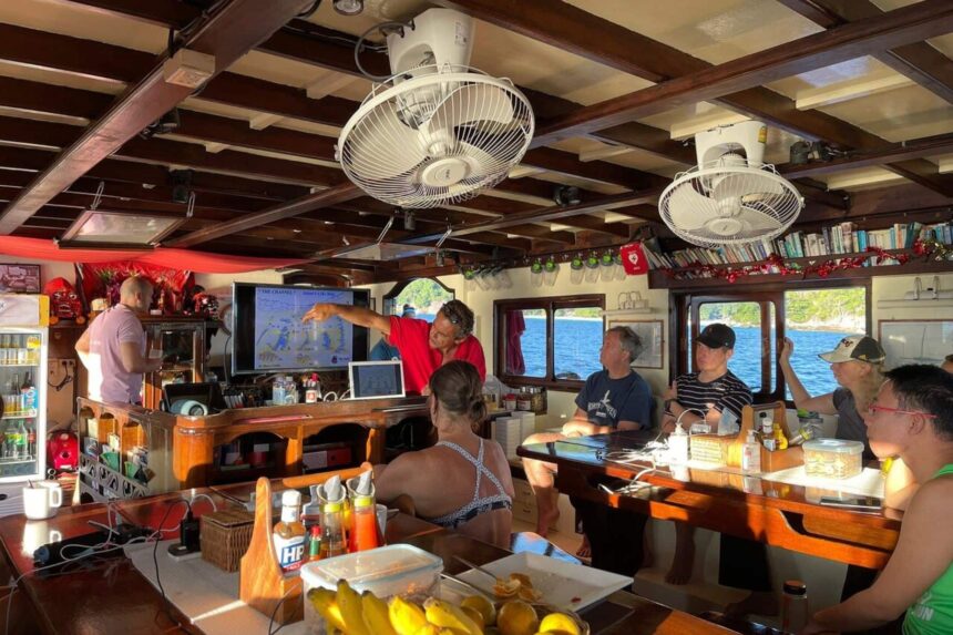 Crew briefing guests on dive sites using a chart at the bar