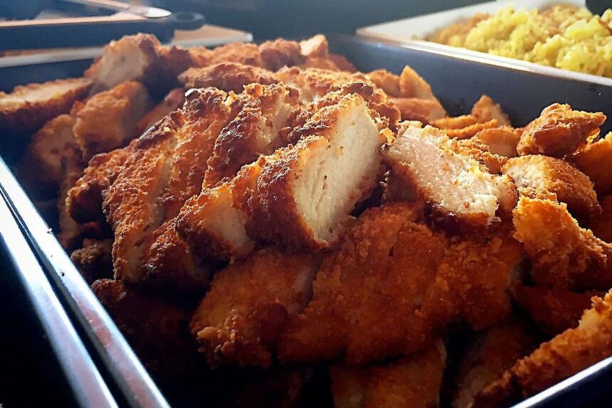 Tray of fried chicken pieces served alongside rice