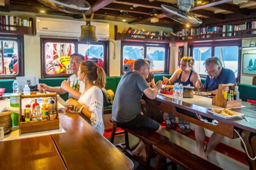 Guests eating together at the long dining table aboard The Junk