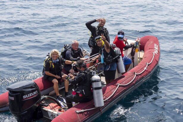 Divers giving the peace sign aboard a red rigid inflatable boat