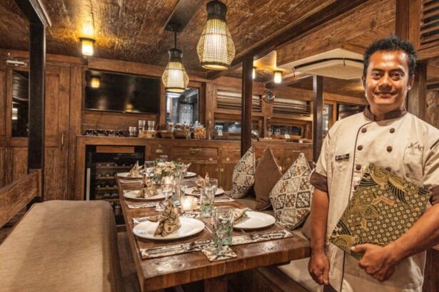 Arenui crew chef standing beside the dining table holding a menu