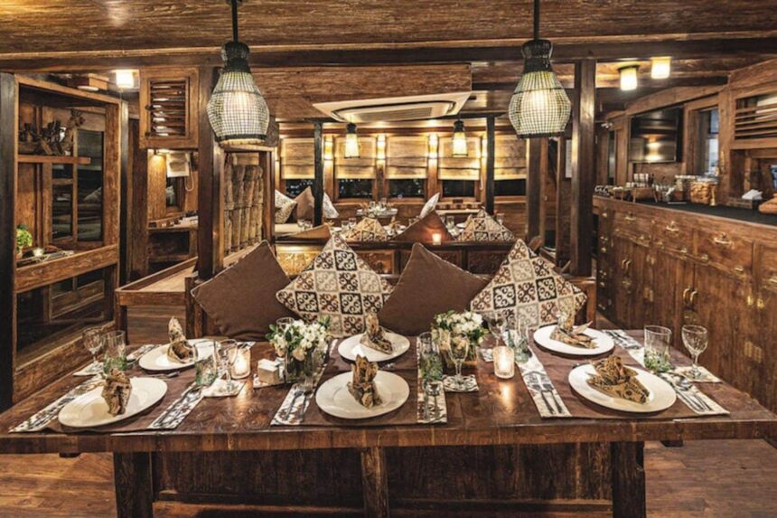 Indoor dining table set with patterned cushions aboard the Arenui