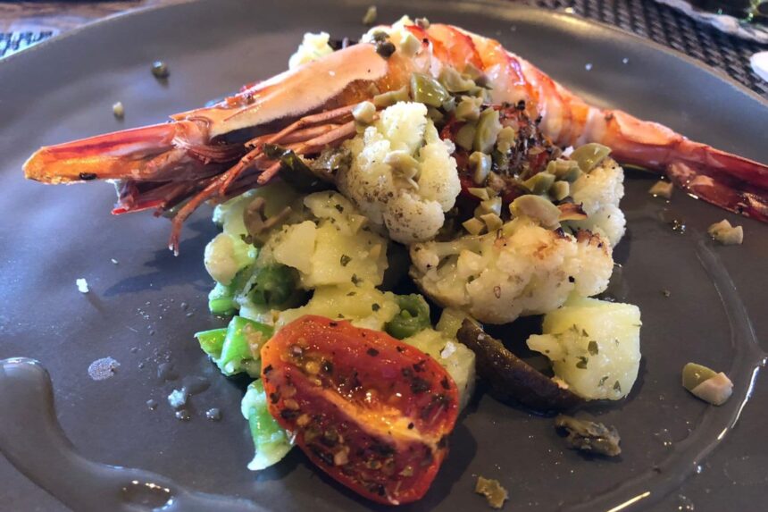 Grilled prawn served with roasted cauliflower and cherry tomatoes on the Arenui