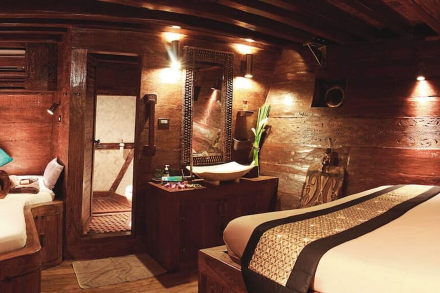 Wood-paneled cabin aboard the Arenui with an ensuite bathroom