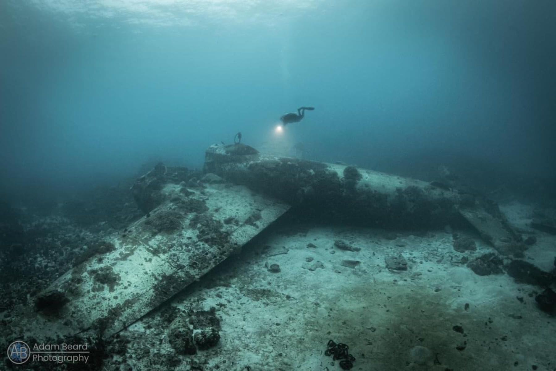 Diver approaching a sunken WWII aircraft wreck near the Pacific Master