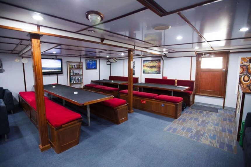 Dining and lounge area with red bench seating aboard the Pacific Master