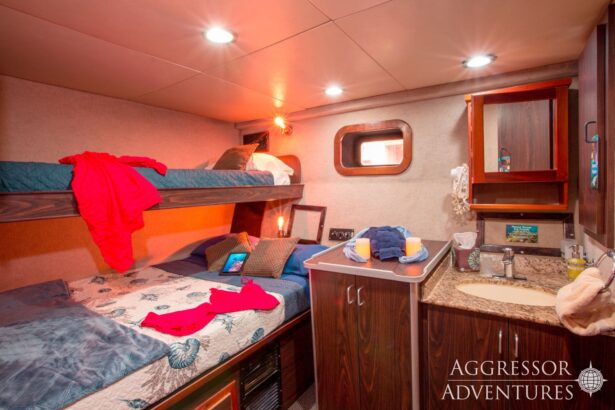 Bunk cabin aboard the Roatan Aggressor with red towels and a small vanity