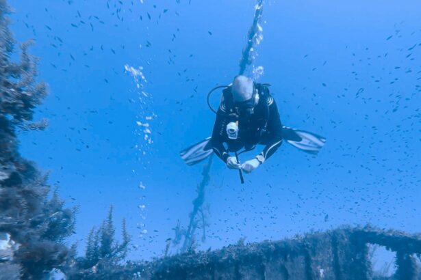 Our tester finning above a wreck with the Insta360 X3 in hand as small fish swarm around