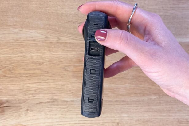 Hand holding the Insta360 X3 side on to show the USB-C charging port under its cover