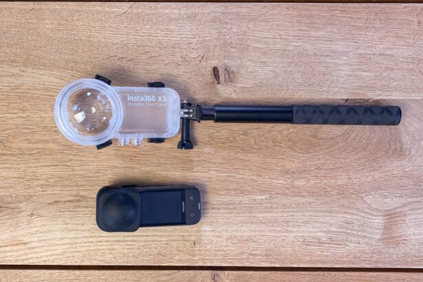 Insta360 X3 with lens guard laid out beside the Invisible Dive Case and extended selfie stick on wood