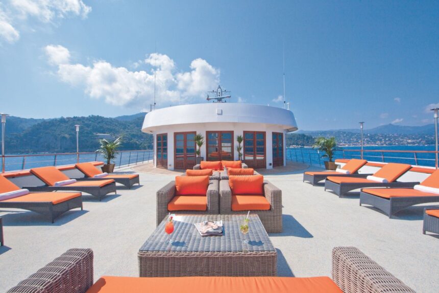 Rattan lounge furniture and orange cushions on the ship's outdoor deck