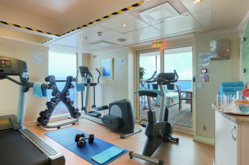 Onboard gym with treadmills, weights and a view of the ocean deck